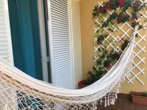 a hammock on a balcony with flowers and plants at Refugio Madeira in Caniço