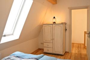 a bedroom with a white cabinet and a window at Gästhuus - Urlaub aan de Ostsee in Timmendorfer Strand