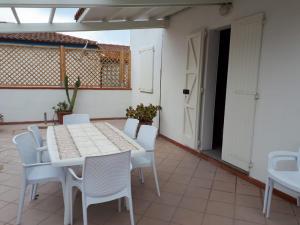 Calasetta casa al mare في كالاسيتا: طاولة بيضاء وكراسي على الفناء