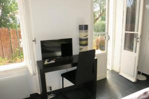 Cette chambre comprend un bureau avec une télévision et une chaise. dans l'établissement Villa les Lys, à La Seyne-sur-Mer