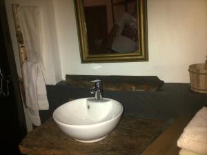 uma casa de banho com um lavatório branco e um espelho. em ETABLE DE LILOU em Sébrazac