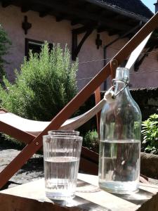 uma garrafa de vidro e um copo de água sobre uma mesa em ETABLE DE LILOU em Sébrazac