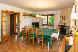 cocina y comedor con mesa verde y sillas en Cal Roig - Pedraforca, en Saldes