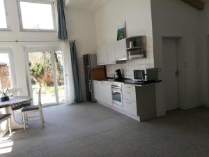 a kitchen with white appliances and a table and a window at Sunny Loft Haus RV in Ravensburg +8 photos
