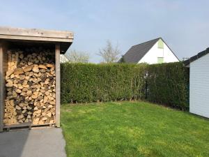 une pile de bois de feu dans un hangar à côté d'une haie dans l'établissement Nieuwendamme 88, à Nieuport