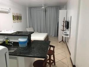 um quarto com uma cozinha e uma sala de estar em Loft da prainha 117 em Arraial do Cabo