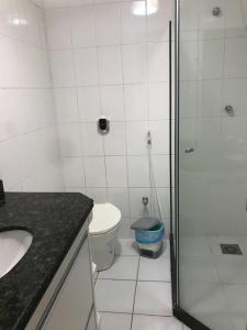 uma casa de banho com um chuveiro, um WC e um lavatório. em Loft da prainha 117 em Arraial do Cabo