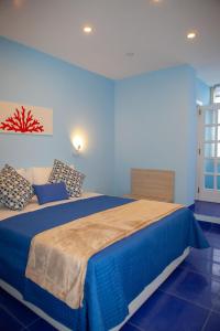 a blue bedroom with a large bed with blue walls at Il Borgo Antico Sorrento Sea View in Sorrento