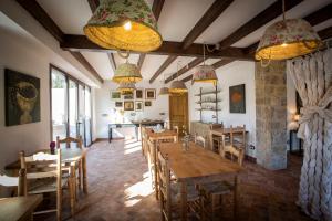 un comedor con mesas, sillas y lámparas de araña en Mas El Barber (Adults only), en Mallol