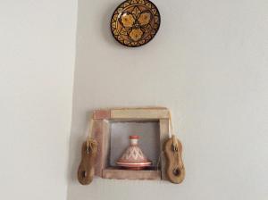 een klok en een doos met een vaas op een muur bij Apartamento Rural Castildetierra in Arguedas