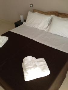 カザラーノにあるB&B In Salentoのベッド1台(折りたたみ式の白いタオル2枚付)