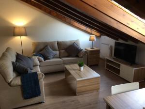 Una sala de estar con un sofá y un televisor. en Apartamentos La Solana, en Potes 6 fotos más