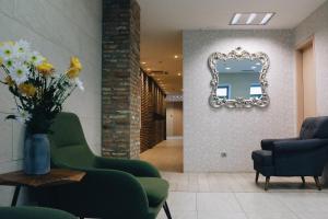 a lobby with two green chairs and a mirror at Maison Boutique Hotel in Tbilisi City