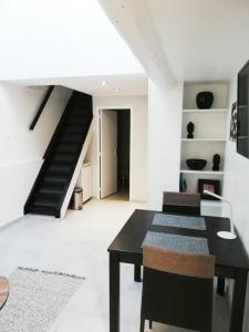 ein Wohnzimmer mit einem schwarzen Tisch und einer Treppe in der Unterkunft Duplex Denim in Nîmes