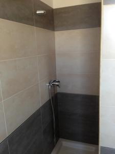 カザラーノにあるB&B In Salentoのグレーとブラウンのタイル張りのバスルーム(シャワー付)