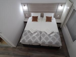 um quarto com uma cama com lençóis brancos e almofadas em Apartments AS Dubrave em Dubrave Gornje