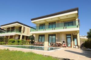 a large house with a swimming pool in front of it at Gold City Premium Private Pool Villa with Free Aqua Park in Alanya