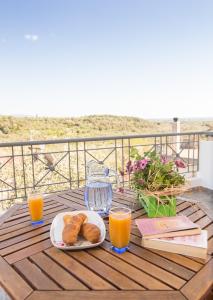 una mesa con un plato de pan y dos vasos de zumo de naranja en Elea en Kalamata