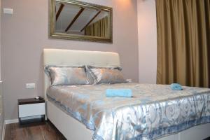 a bedroom with a bed with a mirror on the wall at Apartment Oaza in Mostar +29 photos