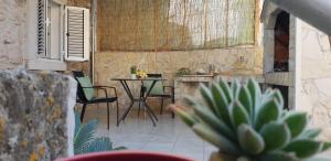 eine kleine Terrasse mit einem Tisch und Stühlen in einem Zimmer in der Unterkunft Studio Apartment Klaric in Vis