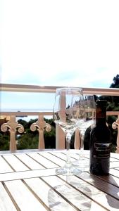 a bottle of wine and two glasses on a table at Arianna in Paleokastritsa