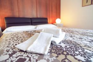 - deux serviettes blanches assises sur un lit dans l'établissement Villa Wanda - Residenza di charme, à Trani