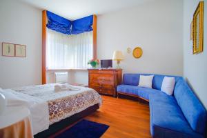 een woonkamer met een blauwe bank en een bed bij Villa Wanda - Residenza di charme in Trani