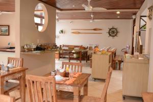 a kitchen and dining room with tables and chairs at Pousada Caiçara in Abraão