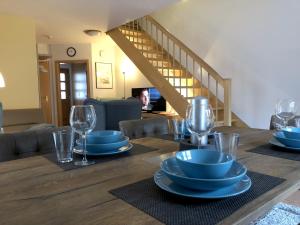 a wooden table with blue plates and glasses on it at MeerZeit in Zingst