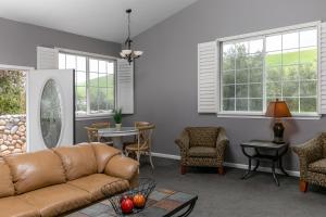 ein Wohnzimmer mit Sofa, Stühlen und Fenstern in der Unterkunft Purple Orchid Resort & Spa in Livermore