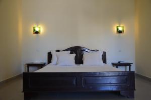 um quarto com uma cama com duas luzes na parede em SAARA HOTEL em Mahajanga