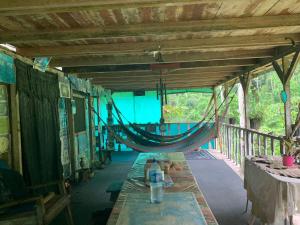 a hammock on a porch of a house at Paraisoverde-Corcovado Over Night in Drake