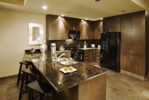 a kitchen with a black refrigerator and a counter top at 3 Br CONDO AVAILABLE IN LAS PALOMAS SANDY BEACH in Puerto Peñasco