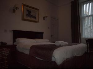 twee bedden in een hotelkamer met handdoeken erop bij Argyll Arms Hotel in Campbeltown