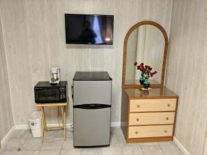 a kitchen with a small refrigerator and a mirror at Oakview Hotel in Wildwood