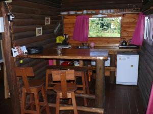 una cocina con mesa y sillas en una cabaña en Cabañas de la Ribera en San Pedro