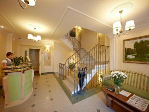 a lobby with a staircase and a woman in a room at Dvor Podznoeva - Business building in Pskov