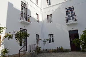 un edificio blanco con ventanas y plantas negras en Alcacer River Apartment, en Alcácer do Sal