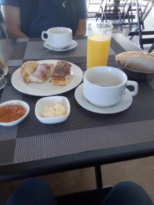 una mesa con platos de comida y un vaso de zumo de naranja en Alojamiento Termal Guaviyú, en Termas de Guaviyú