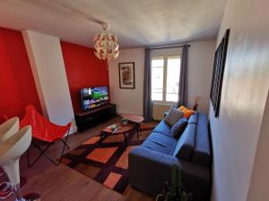 sala de estar con sofá azul y TV en Appt 2 pièces à 18 mn du château de Versailles en Le Port-Marly