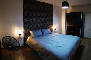 馬爾利港的住宿－Appt 2 pièces à 18 mn du château de Versailles，一间卧室配有一张带蓝色床单的大床和两盏灯。