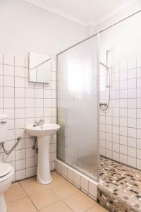 a bathroom with a shower and a sink and a toilet at Maltahöhe Hotel in Maltahöhe