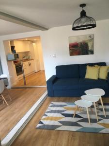 a living room with a blue couch and a table at Les Appartements de Home Petite Venise in Colmar