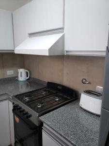 eine Küche mit Herd und Arbeitsplatte in der Unterkunft Departamento Centrico in Villa María + 1 Foto