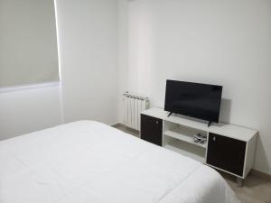 ein Schlafzimmer mit einem Bett und einem Flachbildfernseher in der Unterkunft Departamento Centrico in Villa María