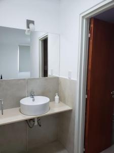 ein Badezimmer mit einem weißen Waschbecken und einem Spiegel in der Unterkunft Departamento Centrico in Villa María