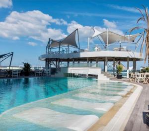 a large swimming pool with a building in the background at White Tower Mamaia - Private Apartment in Mamaia