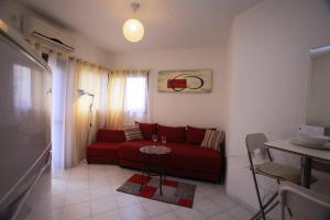 a living room with a red couch and a table at Elena Apartments in Tel Aviv