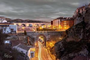 eine Stadt in der Nacht mit einer Brücke und Gebäuden in der Unterkunft alojamientosteruelmarqueses El Marqués in Teruel