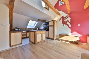 a kitchen with wooden floors and a red wall at Locations des 3 sommets avec Sauna et Spa en Alsace in Sondernach